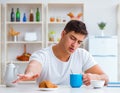 Man falling asleep during his breakfast after overtime work Royalty Free Stock Photo