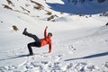 Man falling on its back on snow, with a funny body position, at Malaiesti Valley, Bucegi mountains, Romania, on a sunny Winter day