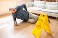 Man Falling On Wet Floor In Front Of Caution Sign Royalty Free Stock Photo