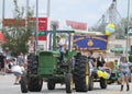 Man or farmer driving a large tractor in a parade in small town America