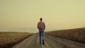 Man farmer walking at road sunset field alone. Business agronom countryside Royalty Free Stock Photo