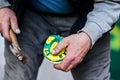 Man farrier installing plastic horseshoe to hoof. Closeup up detail to hands holding animal feet and blurred hammer