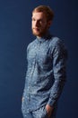 Man, fashion and chic clothes in studio with unique style, denim and trendy on blue background. Irish odel with hipster