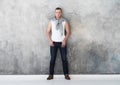 Man, fashion model posing in white t-shirt in jeans in full length Royalty Free Stock Photo