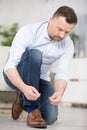 man fastening shoe laces on stylish brown leather shoes Royalty Free Stock Photo