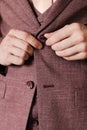 the man fastens the buttons on his jacket