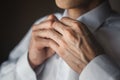 A man fastens buttons on his shirt