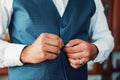 The man fastens the buttons on the waistcoat. Morning of the groom. Hands of wedding groom buttoning up his white shirt Royalty Free Stock Photo