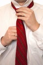 The man fastens a tie