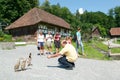 Man feeding ducks in front of old farm houses Royalty Free Stock Photo