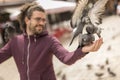 Man feeding flock of pigeons on city square