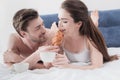 Man feeding his girlfriend in bed Royalty Free Stock Photo