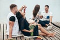 Man feeding his girlfriend grapes sitting on wooden pier on picnic Royalty Free Stock Photo