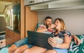 Man feeding his girlfriend a popcorn watching a movie on the tablet in their camper van Royalty Free Stock Photo