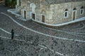 A man feeding pigeons at beautiful floor pattern Monastiraki square in front of ancient church building in the morning