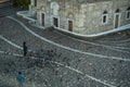 A man feeding pigeons at beautiful floor pattern Monastiraki square in front of ancient church building in the morning with a stan