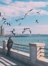 The man feeds birds. Seagulls on the embankment