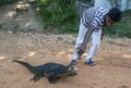 A man feeds a monitor lizard on the side of the road near Polonnaruwa in Sri Lanka.