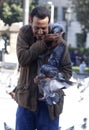 A man feeds pigeons in Catalonia square in Barcelona.