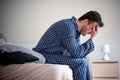 Man feeling bad and seated on the bed Royalty Free Stock Photo
