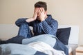 Man feeling bad and seated on the bed Royalty Free Stock Photo