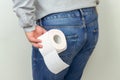 Man feeling pain and holding toilet paper roll, diarrhea, hemorrhoids or constipation Royalty Free Stock Photo