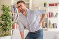 Man suffering backache seated on the sofa Royalty Free Stock Photo