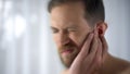 Man feels pain in middle ear, meningitis and hearing loss, inflammation, closeup Royalty Free Stock Photo