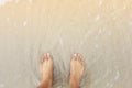 man feet close-up standing on beach ; emotion of sadness concept
