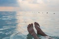 Man feet floating in the sea at morning time. Summer Relax