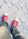 Man feet in red sneakers on cobbled road Royalty Free Stock Photo