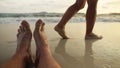 The man feet relaxed are lying on the sandy beach and washed by the water and foam of the ocean. Women& x27;s feet are Royalty Free Stock Photo