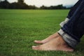 Man feet relaxing on grass enjoying in a day in a park with sky background, Thailand Royalty Free Stock Photo