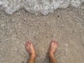 Man feet at seashore.Vacation on ocean beach, feet on sea sand, man walking barefoot in the sand in summer holidays on beach. Royalty Free Stock Photo