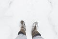 Man in felt boots cleans the path of snow in the village. Rural scene. Copy space.