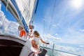 Man and Female sailboat crewmember trimming main sail during sail on vacation in summer season Royalty Free Stock Photo