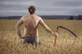 Man in field with scythe