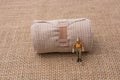 Man figurine in hand on linen canvas background Royalty Free Stock Photo