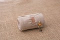 Man figurine in hand on linen canvas background Royalty Free Stock Photo