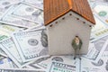 House model and a man figurine on US dollar banknote background Royalty Free Stock Photo