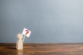 Man figurine with a poster and a question mark. Asking questions, searching for truth. Curiosity, desire to learn more and improve Royalty Free Stock Photo