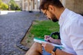 Man Fill Out Application Form. Businessman Sits Near Outdoor And Writes On Paper Forms