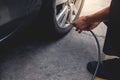 Man filling Air into the Tire. Car Driver Checking Air Pressure and Maintenance his Car