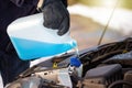 Man filling antifreeze coolant for cleaning front window with snow in background Royalty Free Stock Photo