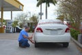 Man filling car tire with air at a gas station with a coin operated compressor pump Royalty Free Stock Photo