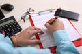 Man is filling form with pen. Picture of clipboard, phone, glasses, pen, form and calculator Royalty Free Stock Photo