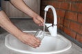 Man filling glass with water from faucet in kitchen Royalty Free Stock Photo