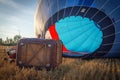 Man filling a hot air balloon on the ground in the field sky and a shining sun background