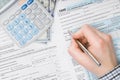 Man filling out 1040 US Tax Form - view from top - studio shot Royalty Free Stock Photo