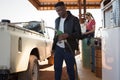 Man filling petrol in car while woman sitting at petrol pump station Royalty Free Stock Photo